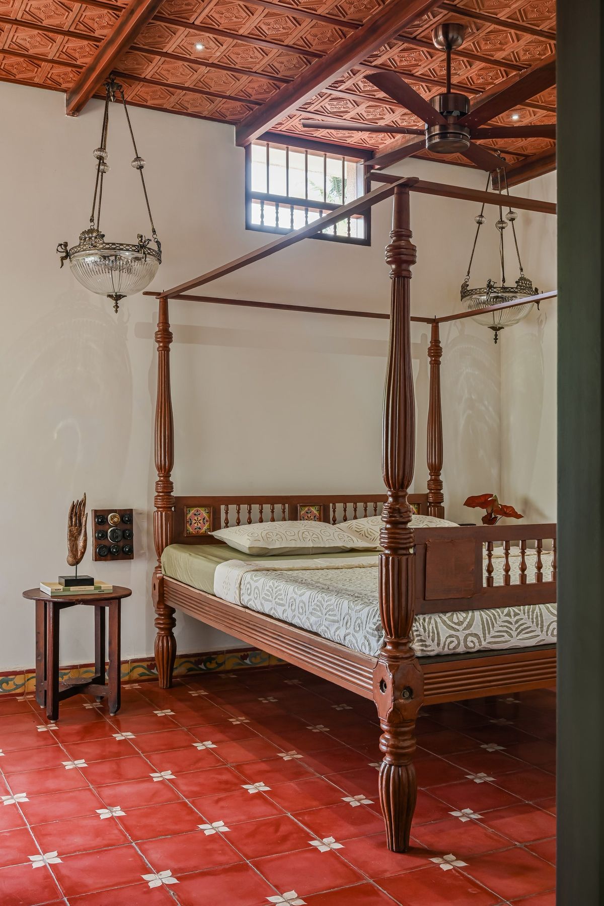 Handcrafted vernacular canopy bed on red tiled floor